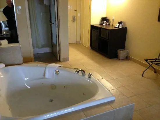 A jacuzzi is set on the side of the hotel's bedroom
